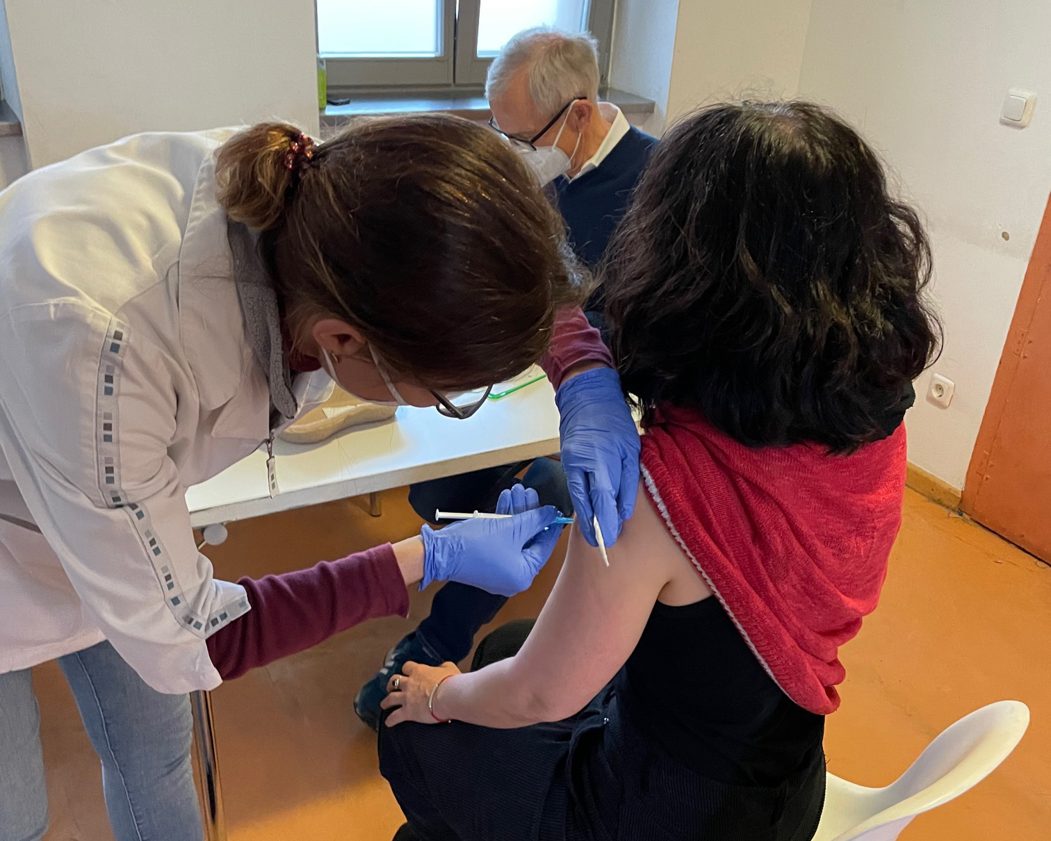 Frau Dr. Köckeritz vom TÜV Rheinland, die für Outlaw als Betriebsärztin agiert, impft eine Kita-Erzieherin; im Hintergrund Prof. Dr. med. Laniado